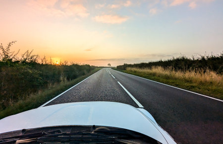 Awe inspiring colours as the sun goes down behind a lovely landscape, seen from a country road, within the United Kingdom.の写真素材