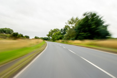 A vehicle view travlling along a countryside road, during the daytime, in the United Kingdom.の写真素材