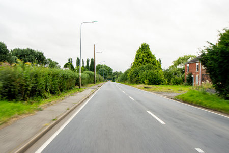 A vehicle view travlling along a countryside road, during the daytime, in the United Kingdom.の写真素材