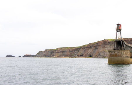 Whitby pier inlet is where boats of all types enter and exit the town's harbour to anchor and offload or onload goods and passengers.の写真素材