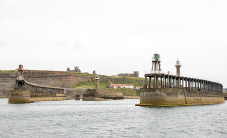 Whitby pier inlet is where boats of all types enter and exit the town's harbour to anchor and offload or onload goods and passengers.の写真素材