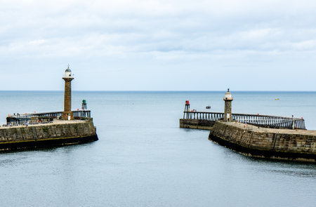 Whitby pier inlet is where boats of all types enter and exit the town's harbour to anchor and offload or onload goods and passengers.の写真素材