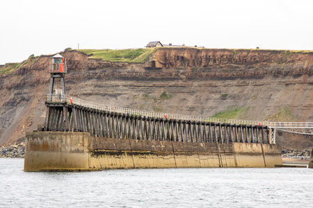 Whitby pier inlet is where boats of all types enter and exit the town's harbour to anchor and offload or onload goods and passengers.の写真素材
