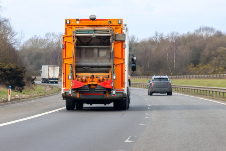 A Bin Lorry Traveling Along A British Motorway taking or collecting rubbish from the next town or city location.の写真素材