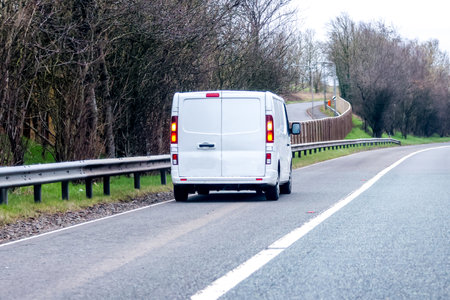 A white van driving down a road.の写真素材