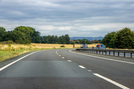 A vehicle view travlling along a quiet motorway, during the daytime, in the United Kingdom.の写真素材