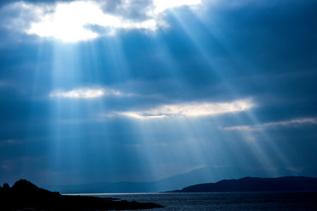 One of mother nature's beautiful spectacles with light beams lighting like a laser down to the ground from the skies above.の写真素材