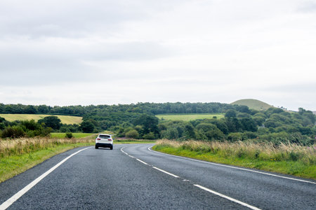 A vehicle view travelling along a countryside road, during the daytime.の写真素材