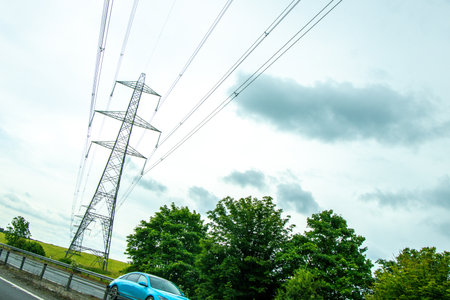 Electricity pylons tower above and stretch across the landscape of the United Kingdom.の写真素材