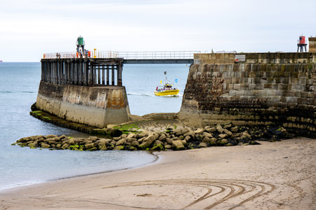 The beaches and coasts of the United Kingdom surrounded by countless sea walls and defenses, here seen a curved wall.の写真素材