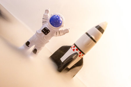 An Astronaut celebrates after some type of Space expedition that has been successful, with a large rocket behind them.の写真素材
