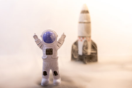 An Astronaut celebrates after some type of Space expedition that has been successful, with a large rocket behind them.の写真素材