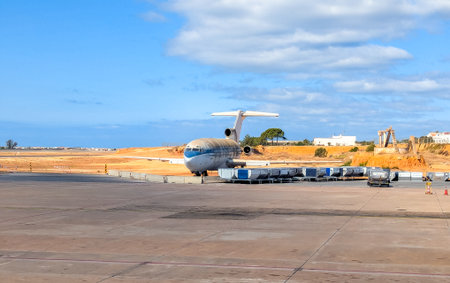 A very old and weathered Boeing 727 aircraft sitting our, fenced off, at an airport and open to the elements.の写真素材