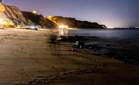 A beautiful night beach setting with the colourful skies and stars over the seafront of a European coastline.の写真素材