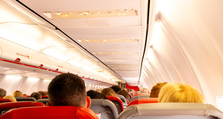 A fully packed passenger aircraft with everyone seated, seen from behind.