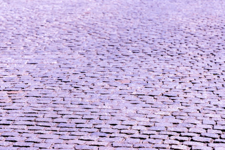 A very old style road made out of cobbles, strong but bumpy for vehicles to drive and people to walk across.の写真素材