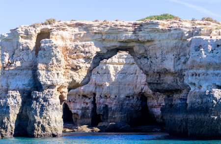 Caves that have been carved by the tests of time by mother nature into the cliff faces of the coastline in Europe.の写真素材