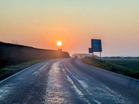 A drive within the United Kingdom as the sun rises or sets creating wonderful colours in the skies above.の写真素材