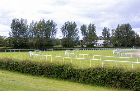 A ground view of a horse racing track that is empty. The long grass strips where horses and jockeys compete to win a race.の写真素材
