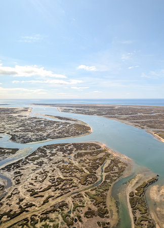A view from above of a water inlet at the coastline. The marshes all around the inlet.の写真素材