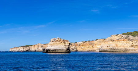 One of the stunning views along the Portuguese coastline, during the heat of day with the sun shining on the cliffs and caves.の写真素材