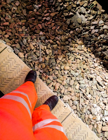 A rail worker standing safe at the side of a railway track.