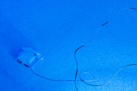 A small robot at the bottom of a resort swimming pool works through the night to clean the dirt etc for the next day's swimmers.の写真素材