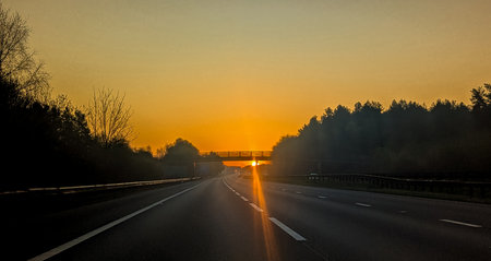 A drive within the United Kingdom as the sun rises or sets creating wonderful colours in the skies above.の写真素材