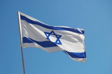 Israel flag on the blue sky backgroundの写真素材