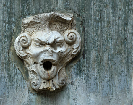 The old stone face on the wall of the castle in Lisbonの写真素材
