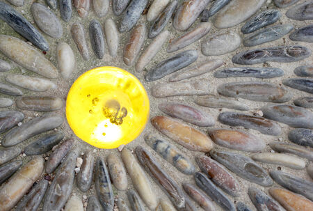 The colorful glass light in the ground with stonesの写真素材