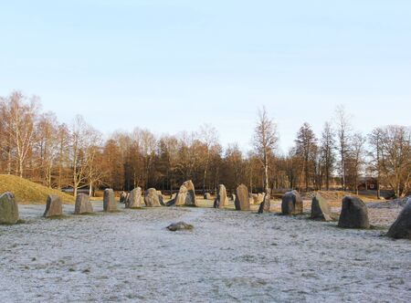 The big stones standing in the snow field in winterの写真素材