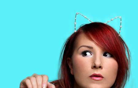 Young curious redhead woman with cat ears portraitの写真素材