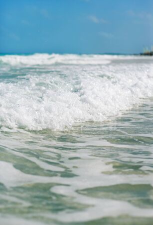 The wave with foam at the shore of the oceanの写真素材