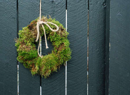 The wreath of moss hanging on the wooden wallの写真素材