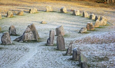 The big stones standing in the snow field in winterの写真素材