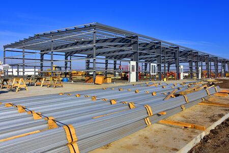 Steel building construction with building material in foreground.の写真素材