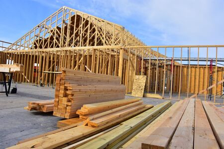 New wood frame home under construction with material in foreground.