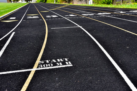 Black athletic running track with white lines to mark lanes.の写真素材