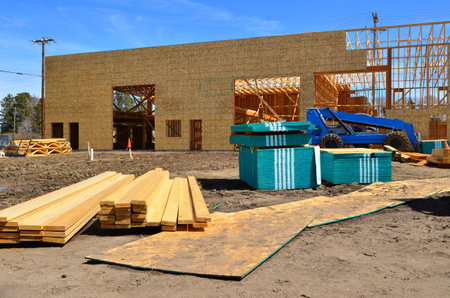 Construction of a new house with wooden boards and a blue truck.