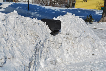 A mailbox stuck in a snowdrift on a sunny winter dayの写真素材