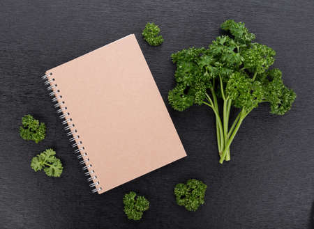 Notebook and parsley isolated on black backgroundの写真素材