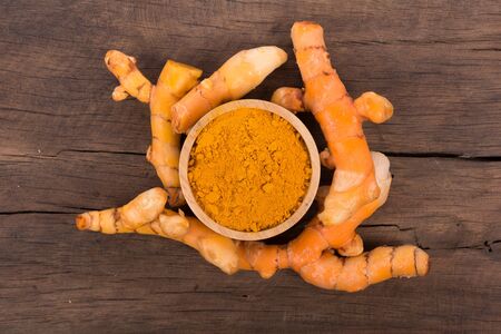 turmeric powder on wooden bowl. top viewの写真素材