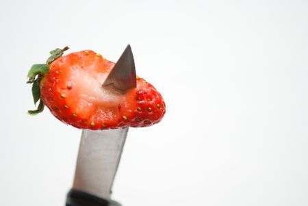 Knife penetrating eaten red strawberryの写真素材