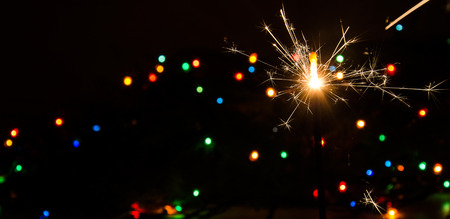 Sparkler and Christmas lights as an ideal backgroundの写真素材