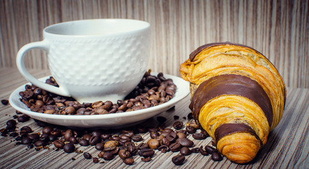 A chocolate croissant with coffee for a hearty breakfast.の写真素材