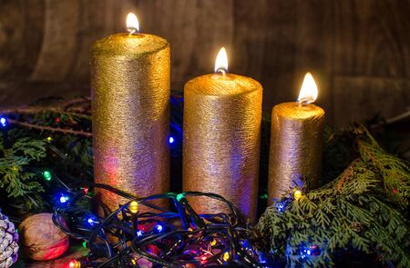 Gold candle and different colors lights are classic symbol of Christmas.の写真素材