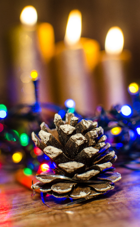 A cone from a tree like a Christmas decoration and a candle backgroundの写真素材