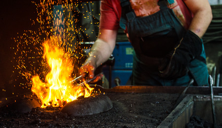 Blacksmith at work, hit with a hammer by a hot metal on the anvil.の写真素材