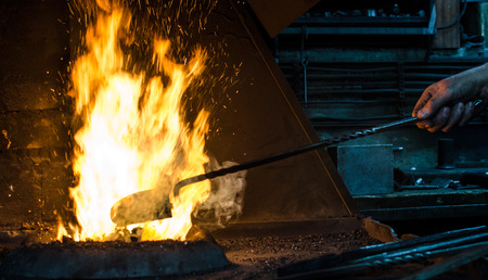Blacksmith at work, hit with a hammer by a hot metal on the anvil.の写真素材
